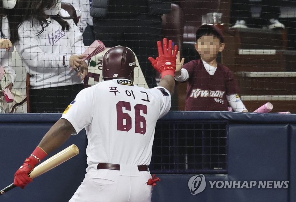 Yasiel Puig of the Kiwoom Heroes high-fives a fan after hitting a solo home run against the LG Twins during the bottom of the third inning of Game 4 of the second round in the Korea Baseball Organization postseason at Gocheok Sky Dome in Seoul on Oct. 28, 2022. (Yonhap)