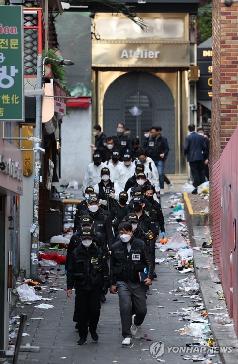 Police officers exit a downhill alley in Seoul's Itaewon district on Oct. 31, 2022, after examining the site of a crowd crush (Yonhap)