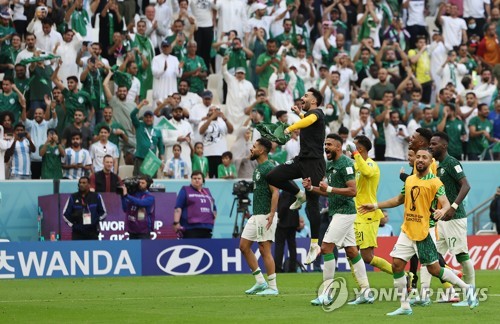 Saudi Arabian players celebrate their 2-1 victory over Argentina in their Group C match at the FIFA World Cup at Lusail Stadium in Lusail, north of Doha, on Nov. 22, 2022. (Yonhap)