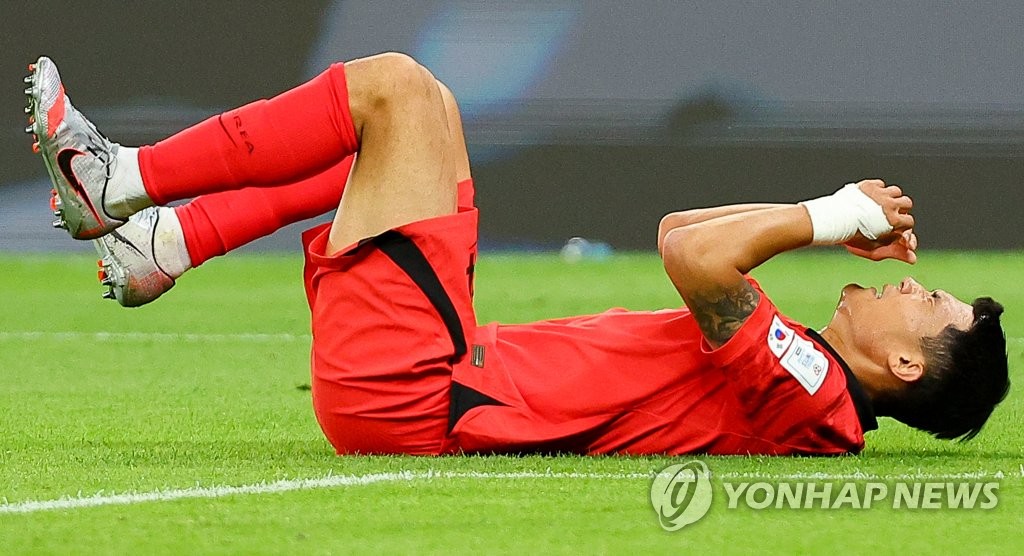 Kim Min-jae of South Korea stays on the pitch in pain during the team's Group H match against Uruguay at the FIFA World Cup at Education City Stadium in Al Rayyan, west of Doha, on Nov. 24, 2022. (Yonhap)