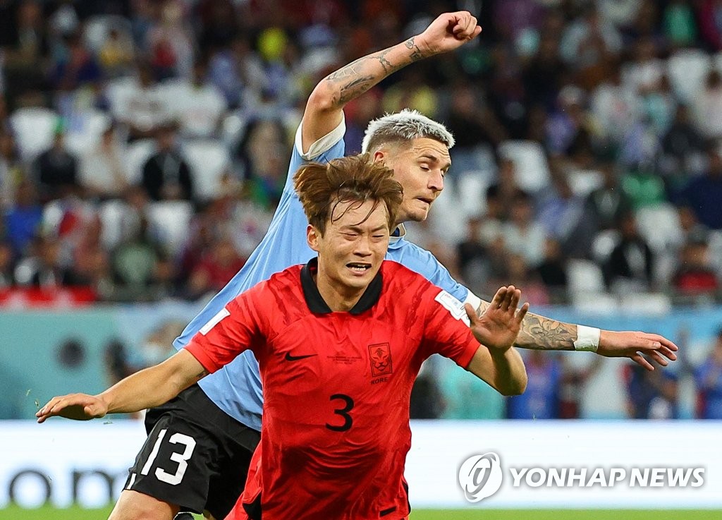 Kim Jin-su of South Korea (front) and Guillermo Varela of Uruguay battle for the ball during the countries' Group H match at the FIFA World Cup at Education City Stadium in Al Rayyan, west of Doha, on Nov. 24, 2022. (Yonhap)