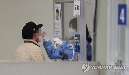 La foto de archivo, tomada el 20 de noviembre de 2022, muestra a un ciudadano recibiendo el examen de coronavirus en un centro de salud comunitario en el distrito de Songpa, en el este de Seúl. 