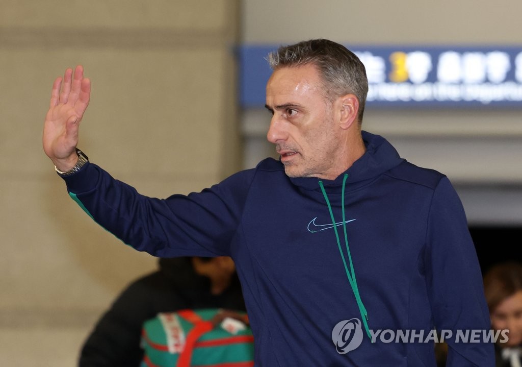 Paulo Bento, former head coach of the South Korean men's national football team, waves to fans gathered at Incheon International Airport, west of Seoul, on Dec. 13, 2022, before departing for his native Portugal. (Yonhap)