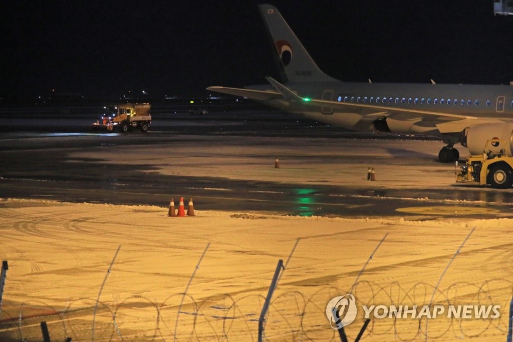 A snowplow works on the runway at Jeju International Airport in Jeju on Dec. 18, 2022. (Yonhap)