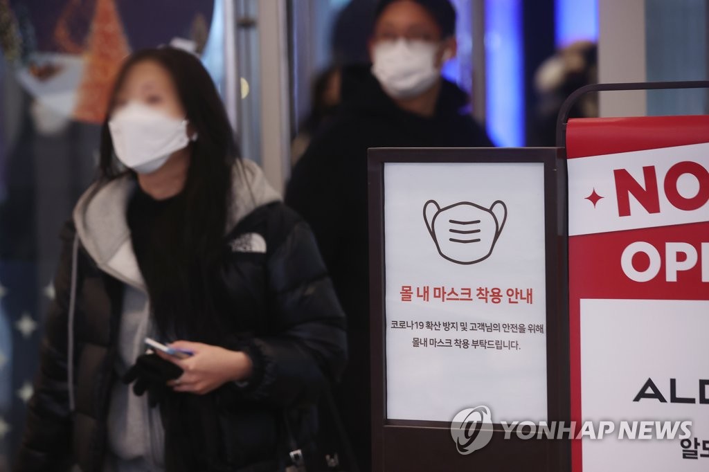 A notice reminding people of the indoor mask rule is placed by the entrance of a shopping mall in Seoul on Dec. 22, 2022. (Yonhap)