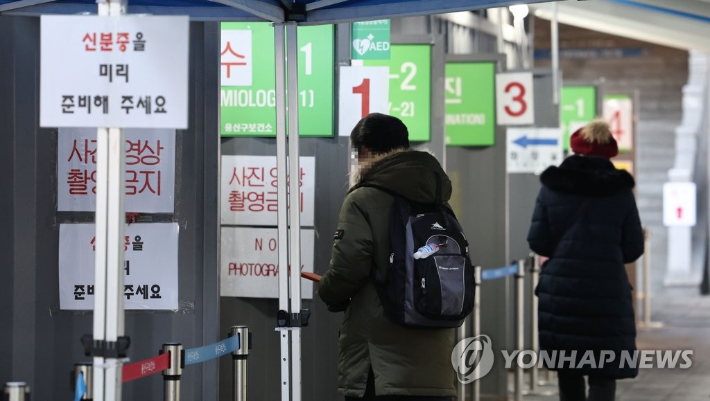 This file photo, taken Dec. 27, 2022, shows people waiting to take coronavirus tests at a public health facility in Seoul's Yongsan Ward. (Yonhap)