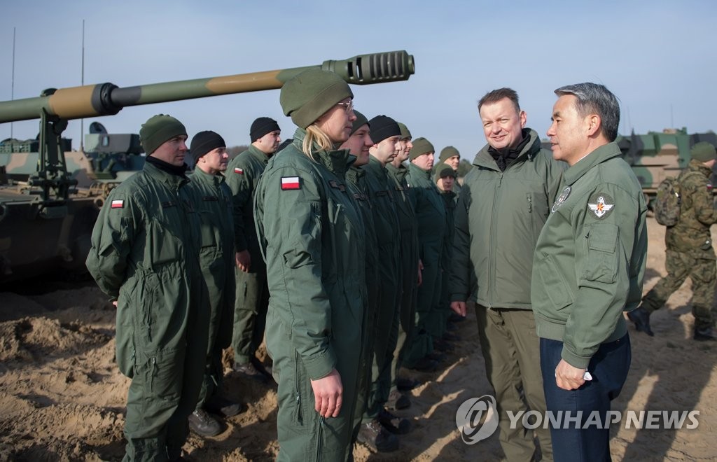 Defense Minister Lee Jong-sup (R) speaks with a Polish soldier operating a K9 self-propelled howitzer at a firing range in Torun, Poland, on Feb. 23, 2023, in this photo released by Lee's office the next day. (PHOTO NOT FOR SALE) (Yonhap)