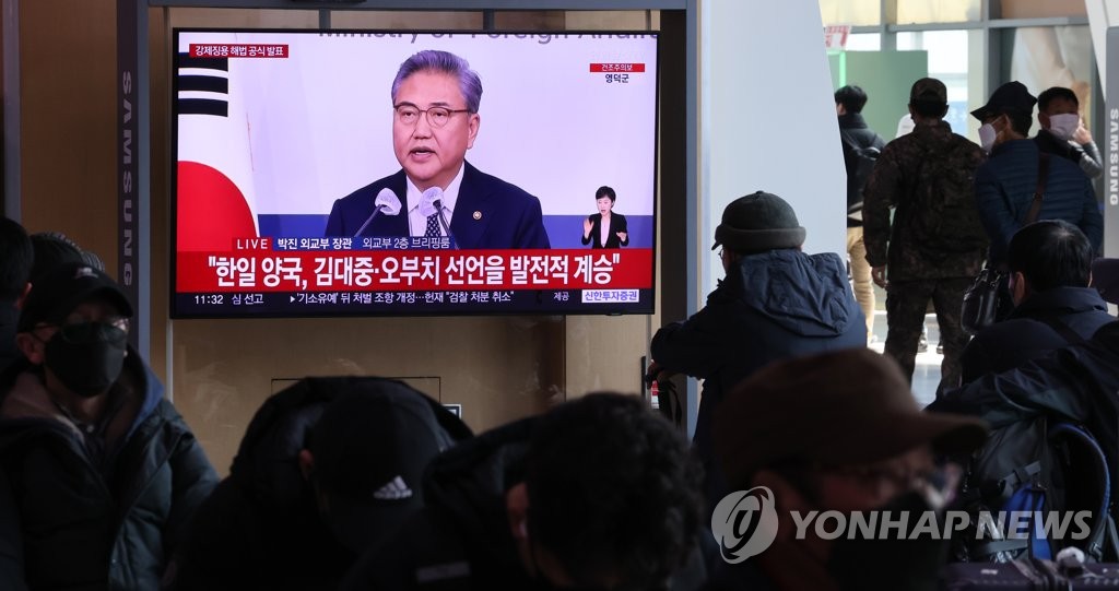 People watch breaking news on the South Korean government's plan to compensate victims of Japan's wartime forced labor through a Seoul-backed public foundation on a television installed at Seoul Station on March 6, 2023. (Yonhap)