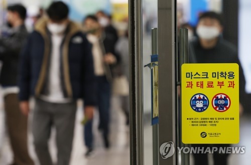 A penalty notice for noncompliance with the mask-wearing policy on public transportation is glued to a glass door at Gwanghwamun Station in central Seoul on March 15, 2023. South Korea will remove the mask requirement for public transportation on March 20. (Yonhap) 