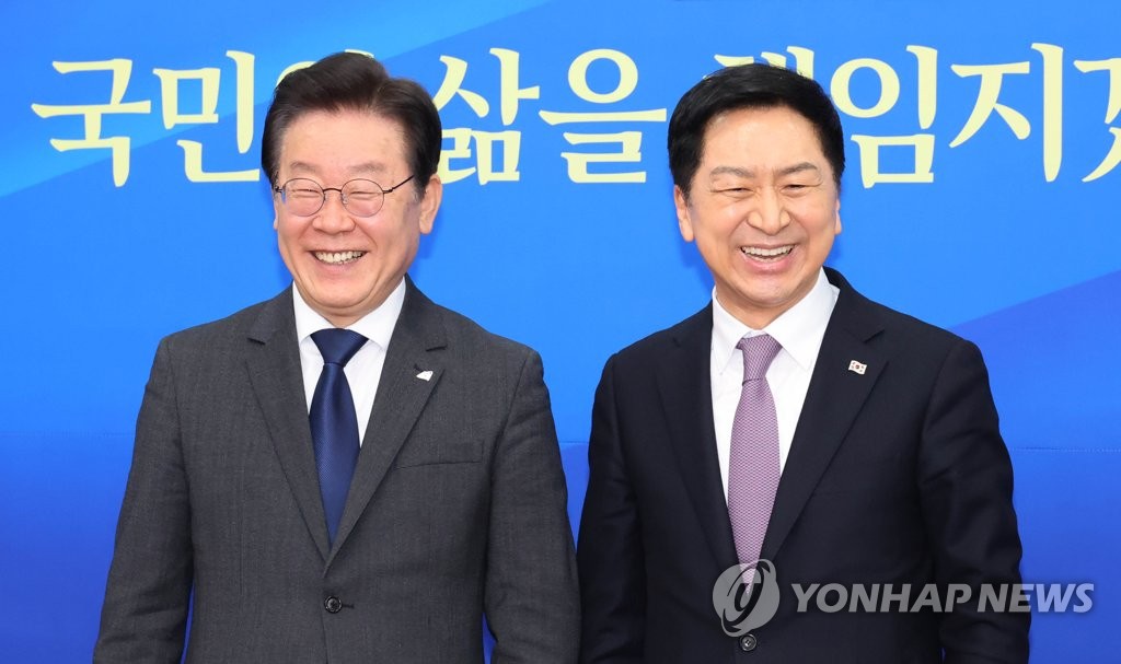 Ruling People Power Party leader Kim Gi-hyeon (R) and main opposition Democratic Party leader Lee Jae-myung pose during their meeting at the National Assembly on March 15, 2023. (Yonhap)