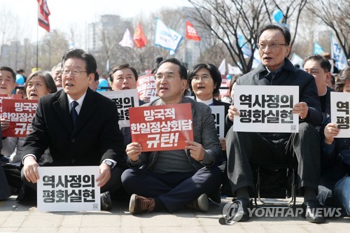 This March 18, 2022, photo shows opposition leader Lee Jae-myung (L) and floor leader Park Hong-keun (2nd from L) attending a rally denouncing the results of a South Korea-Japan summit in central Seoul. (Pool photo) (Yonhap)