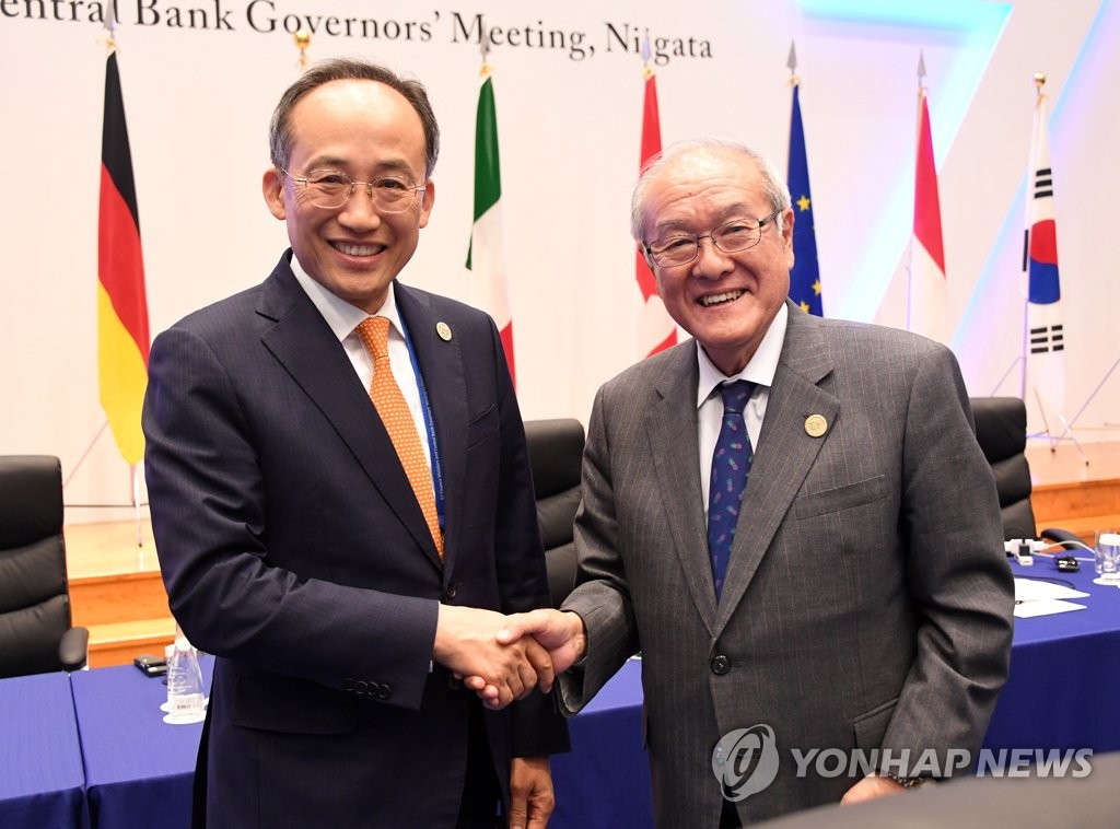 先月１２日、新潟で開かれたＧ７財務相・中央銀行総裁会議で握手を交わす秋経済副首相（左）と鈴木財務相（企画財政部提供）＝（聯合ニュース）≪転載・転用禁止≫