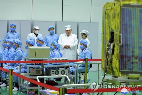 North Korean leader Kim Jong-un (2nd from R, rear), along with his daughter Ju-ae (far R, rear), talks with members of the Non-permanent Satellite Launch Preparatory Committee in Pyongyang on May 16, 2023, to inspect the country's first military reconnaissance satellite, in this photo released by the North's official Korean Central News Agency. (For Use Only in the Republic of Korea. No Redistribution) (Yonhap)