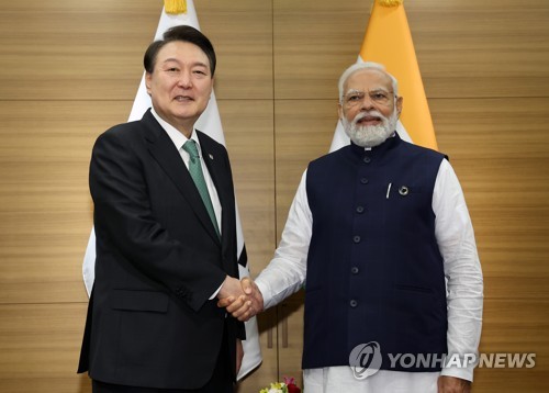 South Korean President Yoon Suk Yeol (L) and Indian Prime Minister Narendra Modi shake hands at their summit at a hotel in Hiroshima, Japan, on May 20, 2023. (Yonhap)