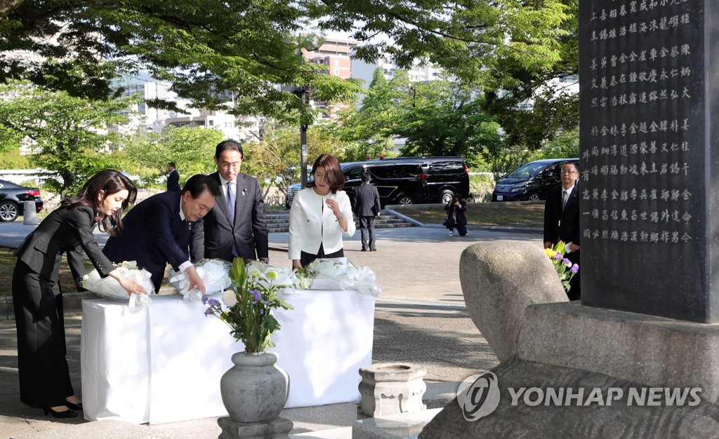South Korean President Yoon Suk Yeol (2nd from L) , Japanese Prime Minister Fumio Kishida (2nd from R), first lady Kim Keon Hee (L) and Kishida's wife, Yuko, pay tribute in front of a cenotaph for Korean victims of the Hiroshima atomic bombing at the Peace Memorial Park in Hiroshima, Japan, on May 21, 2023. (Yonhap)
