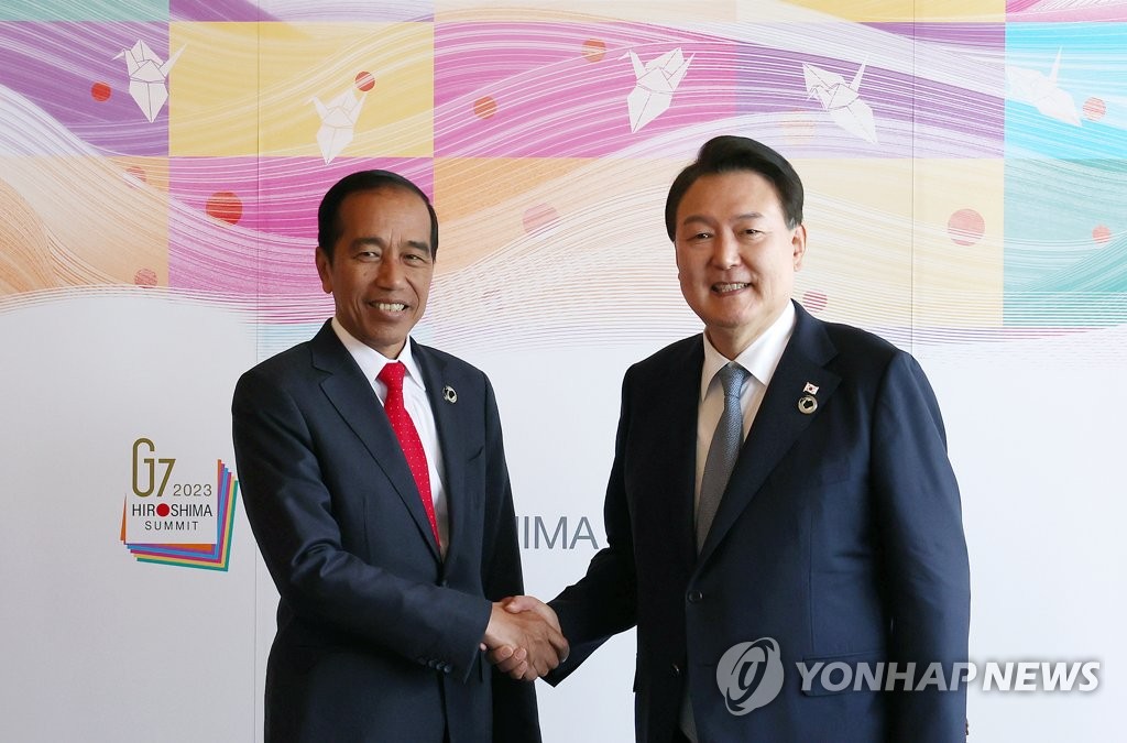 South Korean President Yoon Suk Yeol (R) and Indonesian President Joko Widodo hold a summit in Hiroshima, Japan, on May 21, 2023. (Pool photo) (Yonhap)