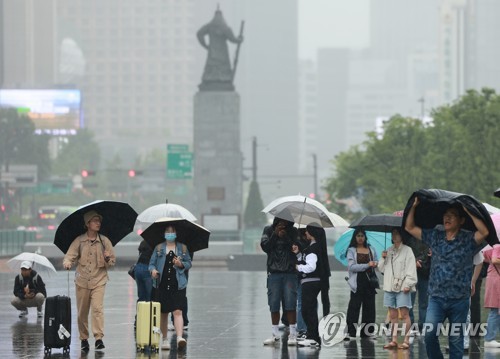 서울 세종대로 광화문광장에서 우산을 쓴 관광객들이 오가고 있다. [연합뉴스 자료사진]