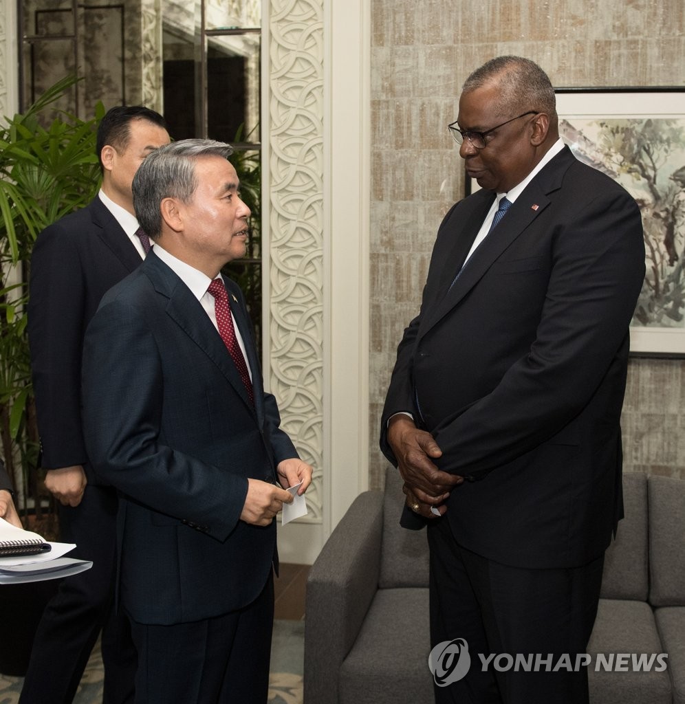 Defense Minister Lee Jong-sup (L) speaks with his U.S. counterpart, Lloyd Austin, before their trilateral talks with Japanese Defense Minister Yasukazu Hamada on the margins of the Shangri-La Dialogue in Singapore on June 3, 2023, in this photo provided by Seoul's defense ministry. (PHOTO NOT FOR SALE) (Yonhap)