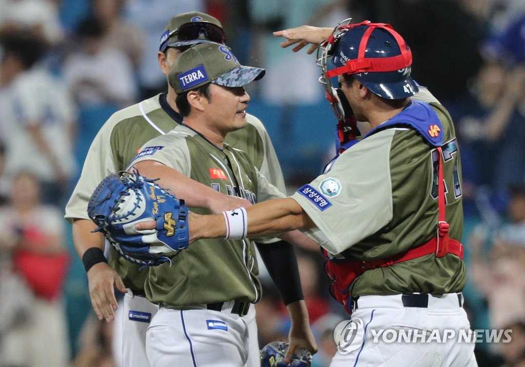 Samsung Lions closer Oh Seung-hwan (C) embraces his catcher Kang Min-ho after recording his 500th professional save in a 9-6 win over the NC Dinos in a Korea Baseball Organization regular season game at Daegu Samsung Lions Park in Daegu, some 235 kilometers southeast of Seoul, on June 6, 2023. (Yonhap)