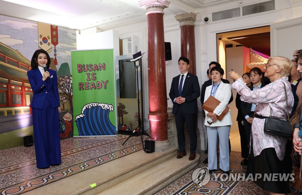 La primera dama Kim Keon Hee (izquierda) hace comentarios durante un recorrido por una exposición sobre Busan en el Centro Cultural Coreano en París el 20 de junio de 2023. (Yonhap)