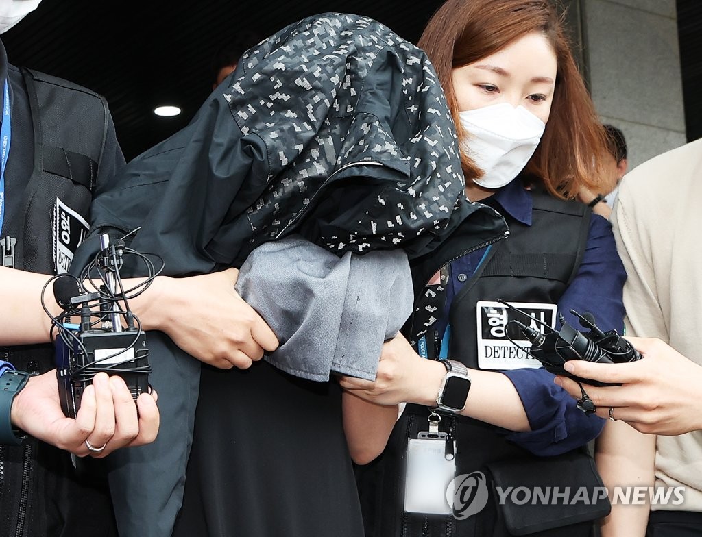 La sospechosa arrestada por presuntamente matar a sus dos bebés recién nacidos y almacenar sus cuerpos en un refrigerador en su casa es escoltada a la oficina del fiscal en Suwon, provincia de Gyeonggi, el 30 de junio de 2023. (Yonhap) 