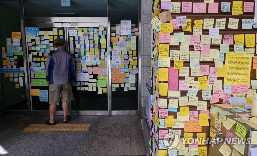 Post-it messages commemorating a school teacher who died cover an entrance and outer wall of an elementary school in southern Seoul on July 26, 2023. (Yonhap)