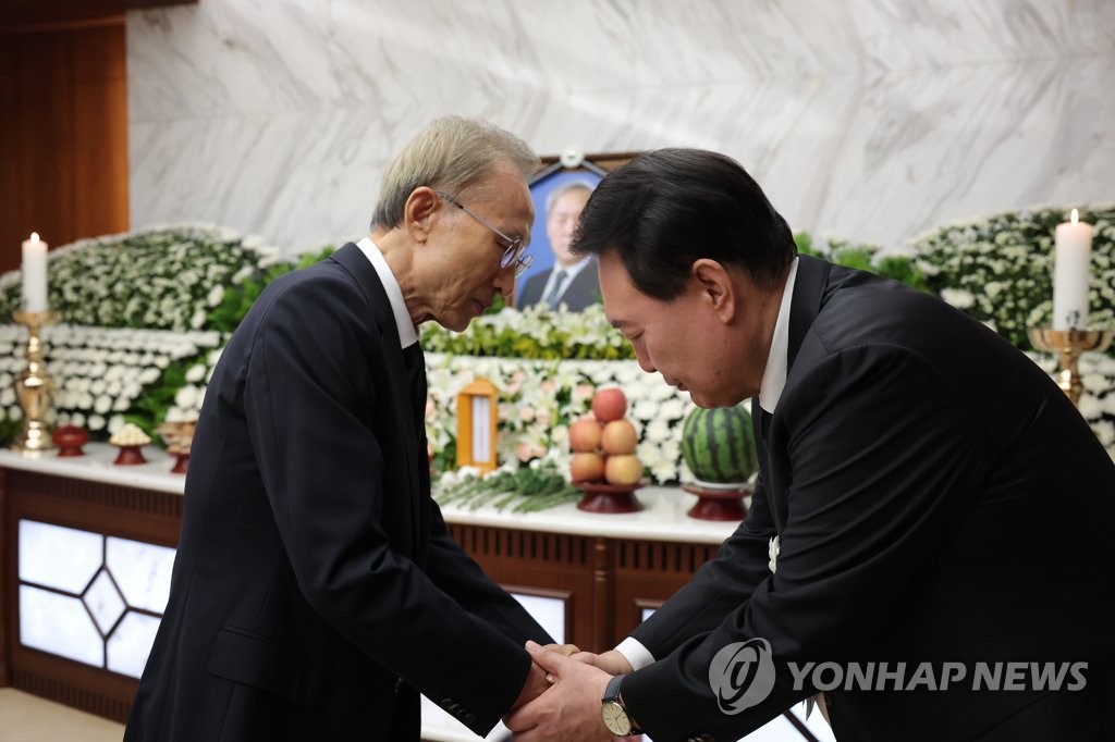 El presidente Yoon Suk Yeol (derecha) estrecha la mano del expresidente Lee Myung-bak durante su visita al funeral del padre de Yoon en el Hospital Severance de Seúl el 15 de agosto de 2023, en esta foto de archivo proporcionada por la oficina presidencial. (FOTO NO A LA VENTA) (Yonhap)