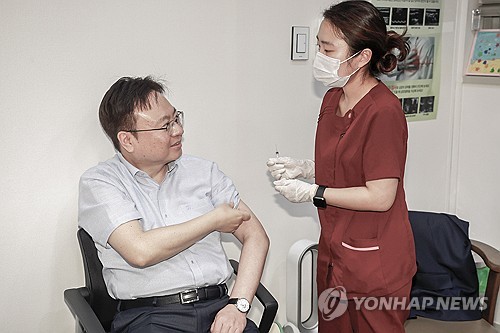 This file photo taken Nov. 1, 2023, shows Health Minister Cho Kyoo-hong (L) receiving a COVID-19 vaccine shot at a hospital in Seoul, in this photo released by the Ministry Health and Welfare. (PHOTO NOT FOR SALE) (Yonhap)