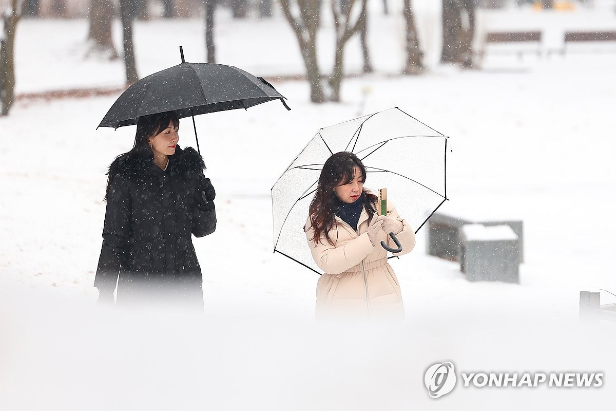 서울 및 경기 지역 등에 대설주의보가 발효된 9일 오후 눈이 내린 서울 여의도공원에서 직장인들이 점심시간을 맞아 산책하고 있다. / 연합뉴스