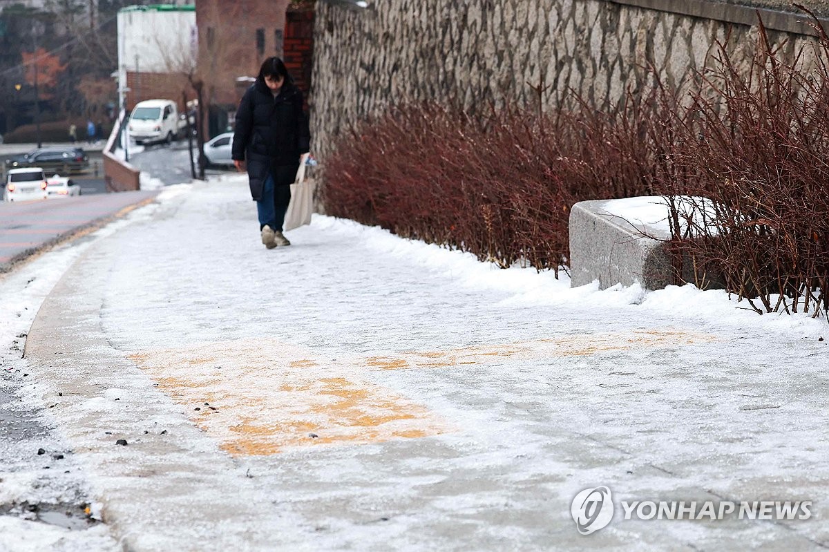 18일 오전 서울 종로구에서 한 시민이 얼어붙은 오르막길을 힘겹게 오르고 있다. / 연합뉴스