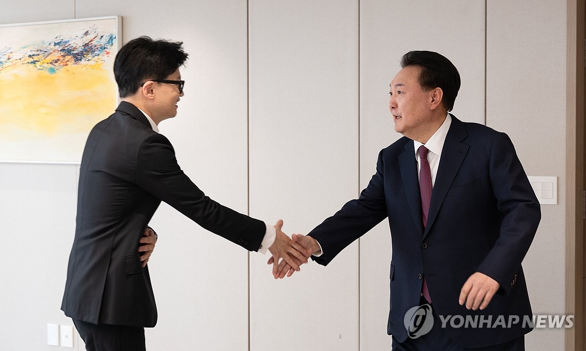 President Yoon Suk Yeol (R) shakes hands with Han Dong-hoon, interim leader of the ruling People Power Party, during their luncheon meeting at the presidential office in Seoul on Jan. 29, 2024, in this photo provided by the presidential office. (PHOTO NOT FOR SALE) (Yonhap)