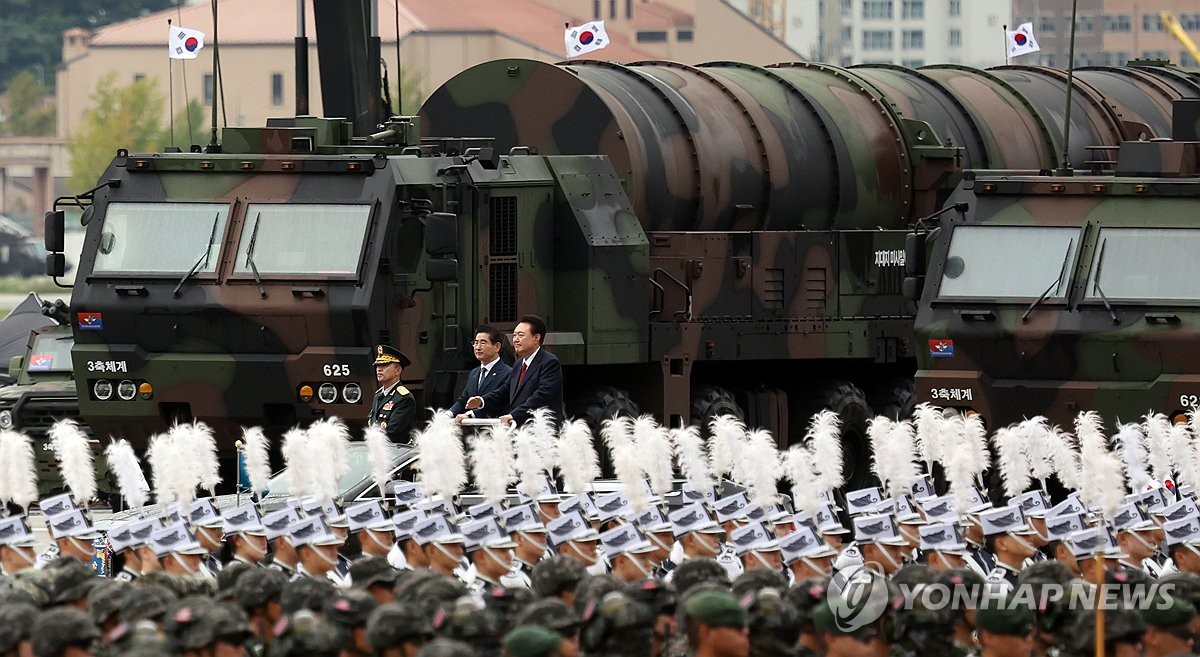 El presidente Yoon Suk Yeol (centro) pasa junto a un lanzador transportador-erector que transporta el misil balístico Hyunmoo-5 durante una ceremonia que conmemora el Día de las Fuerzas Armadas el 1 de octubre de 2024, en la Base Aérea de Seúl en Seongnam, justo al sur de la capital. (Foto de la piscina) (Yonhap)