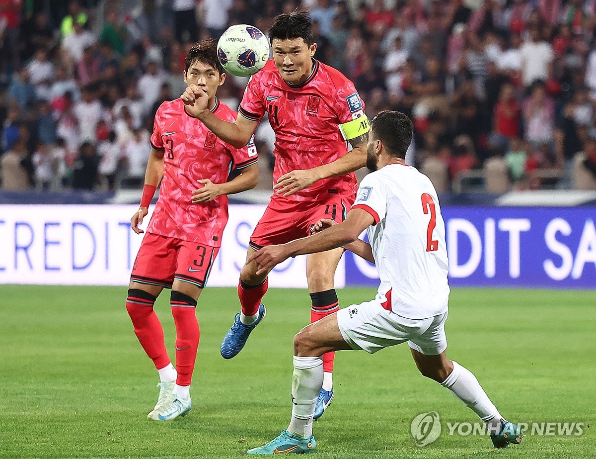 Kim Min-jae of South Korea (C) battles Mohammad Abu Hasheesh of Jordan (R) for the ball during their Group B match in the third round of the Asian World Cup qualification at Amman International Stadium in Amman on Oct. 10, 2024. (Yonhap)