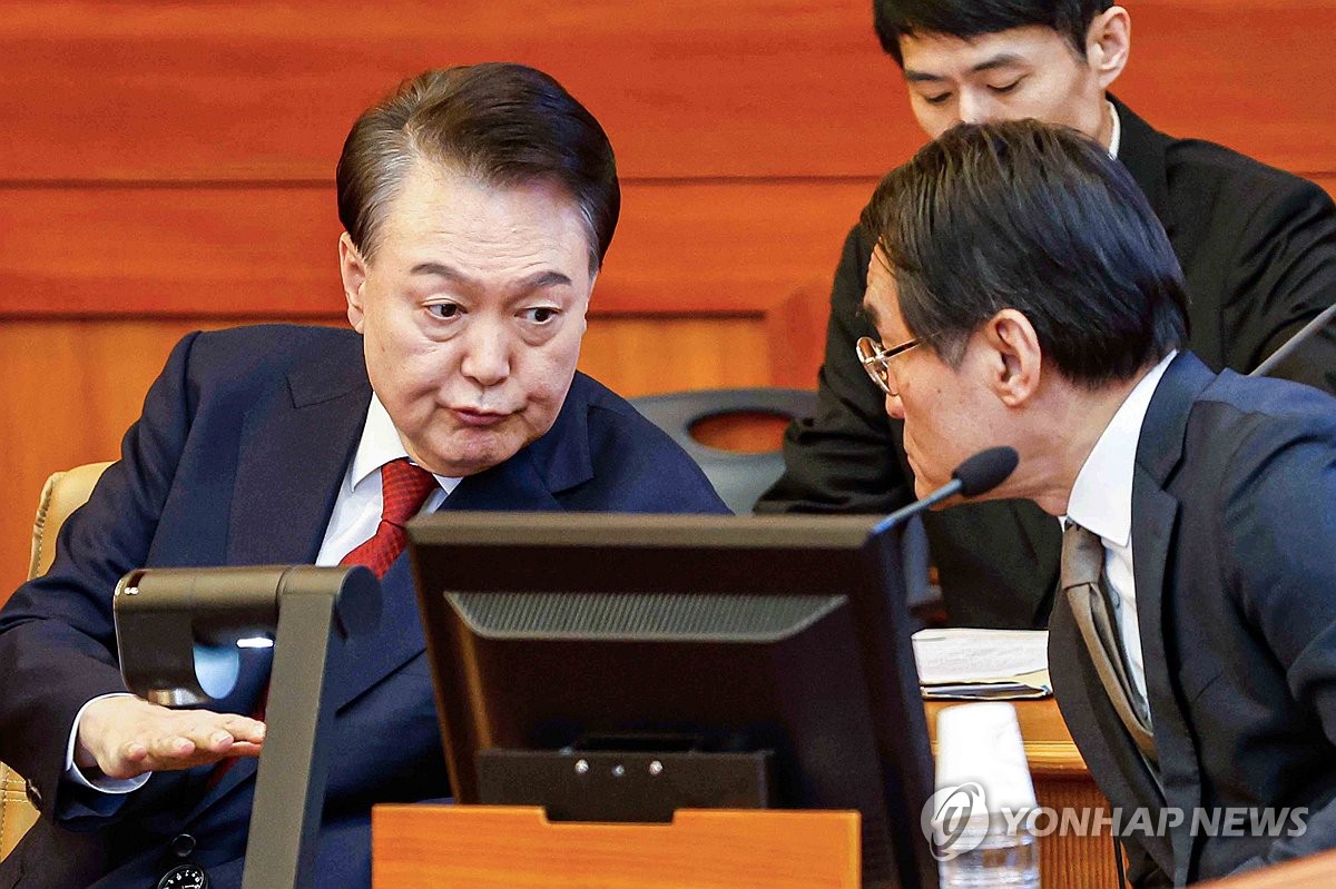 El presidente Yoon Suk Yeol (L) habla con su abogado, Bae Bo-yoon, mientras asiste a la séptima audiencia de su juicio de juicio político en el Tribunal Constitucional en Seúl el 11 de febrero de 2025, por su corta imposición de la ley marcial en la ley marcial. Diciembre. (Foto de la piscina) (Yonhap)